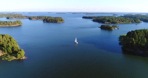 Sailboat in archipelago, Cinema 4k aerial view away from a sail boat, in uusimaa saaristo archipelago, on the gulf of finland, on a sunny evening dawn, in Raasepori, Finland