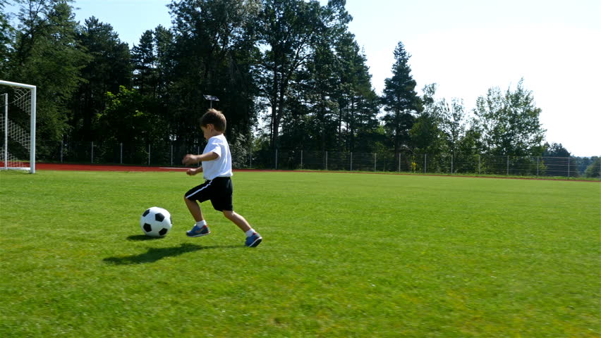 Tracking camera of a little 3 years old boy scoring a goal in a football field Royalty-Free Stock Footage #29805985