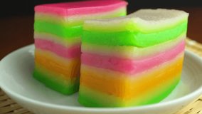 hand peel layer of colorful Kuih Lapis or sticky rice cake in white dish, eating Southeast Asians desserts - Powered by Shutterstock - Get 15% off with code: PIKWIZARD15