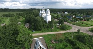 4K aerial video footage view of medieval beautiful white stone church in Troickoye village and area around it near Pereslavl-Zalesskiy on Golden Ring route 130 km from Moscow, Russia in summer day