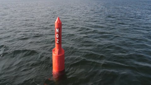 Slow motion shot of stationary, red port lake navigation buoy. Muskoka, Ontario, Canada.
