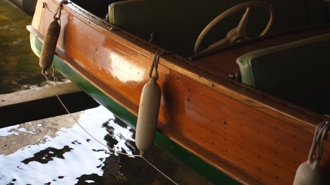 Slow motion shot of antique wooden motor boat in boathouse. Cottage country in Muskoka, Ontario, Canada.
