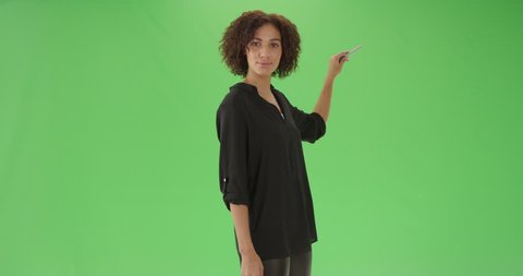 A young black female teacher explains math on green screen. On green screen to be keyed or composited.