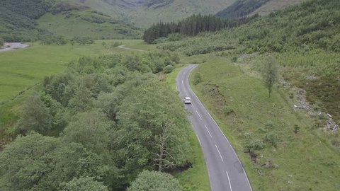 Aerial Shot of Car Driving Along Country Road in Scotland