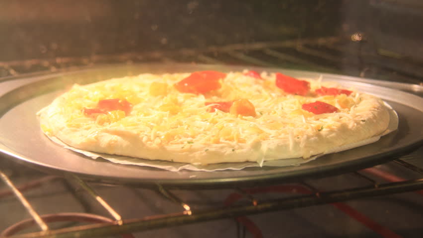 Pizza Bubble Timelapse. Small pizza in an electric home oven being cooked. Shot