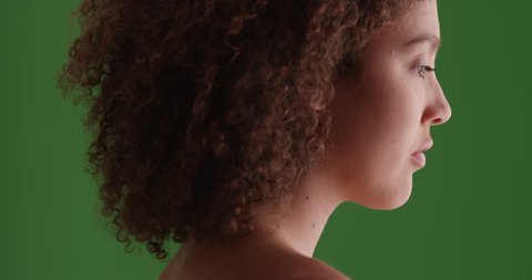 Black girl looks on green screen. On green screen to be keyed or composited.