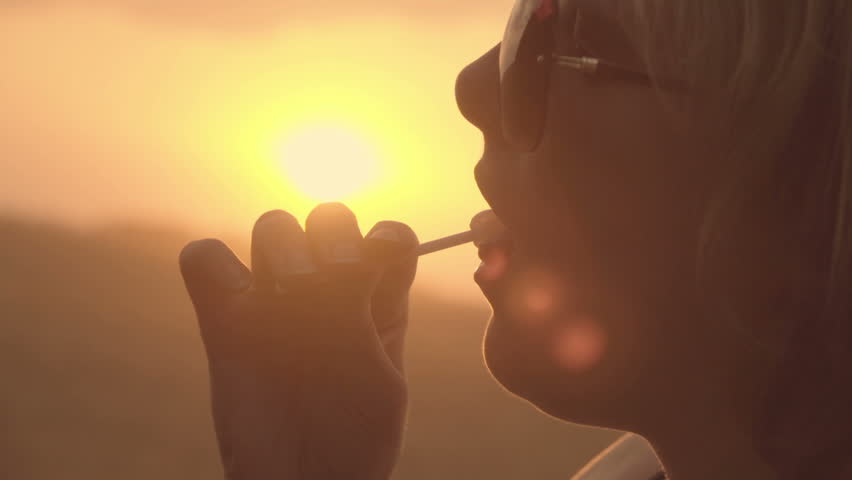 Girl eating lollipop, close-up face at sunset. Slow motion  | Shutterstock HD Video #29824903