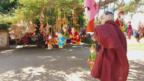 Traditional colorful handcrafted puppets hang on trees, monk puppet, Bagan