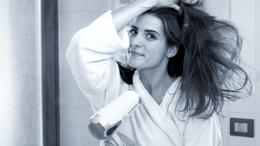 Beautiful woman making long hair fly with blow dryer super slow motion lookin