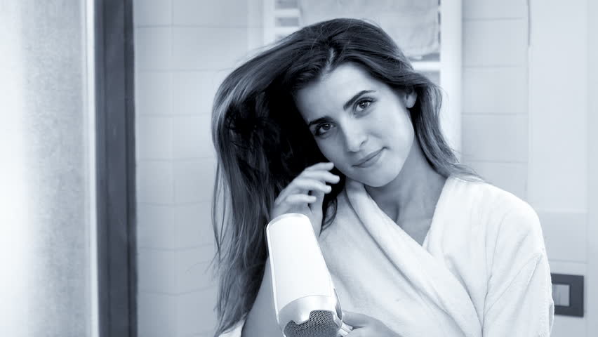 Beautiful woman making long hair fly with blow dryer super slow motion lookin