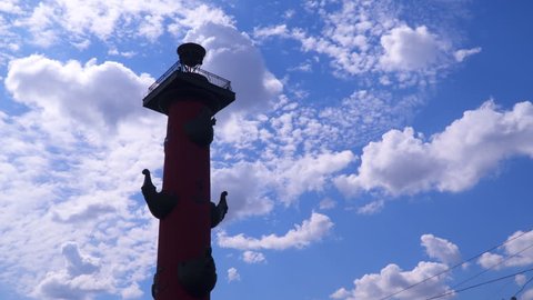 Silhouette of a rostral column against a sky with clouds. Saint-Petersburg, Russia
