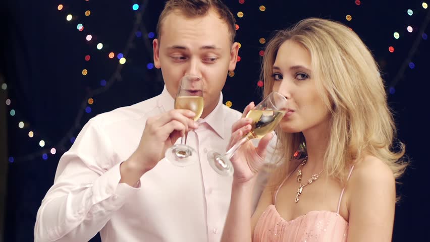 Handsome man brings champagne to girlfriend at party