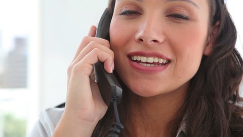 Happy businesswoman answering the phone in an office