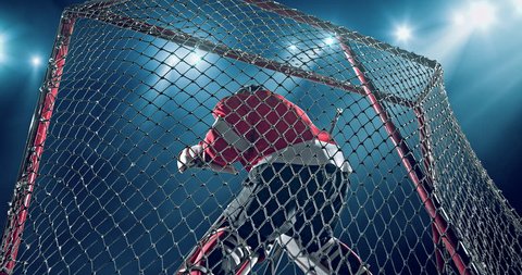 Ice Hockey goalie fails a goal on a dark background with intensional lens flares. He is wearing unbranded sports clothes.