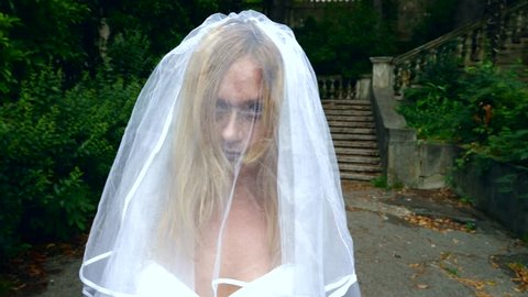 The ghost of the bride wanders through the ruins of the old castle. Bride of the Zombie. 4 k. Slow-motion shooting