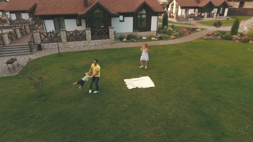 father turns his son on the lawn