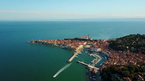 4K. Flight over old city Piran in the morning, aerial panoramic view with Tartini Square, St. George's Parish Church, marina and old houses. 