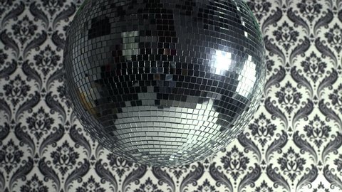 a funky discoball spinning with retro wallpaper background. perfect clip for club visuals or party/celebration
