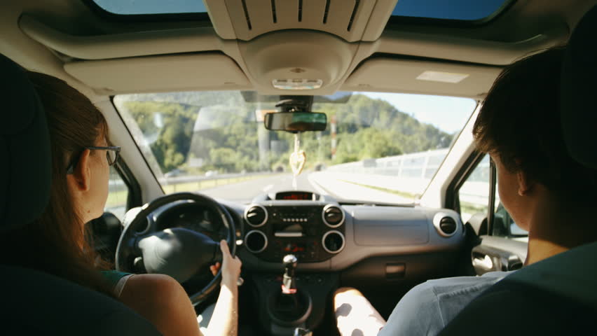 Trip view. Convertible Driver's Seat, Front Windshield view. View from the car from the Driver's Seat. Reaching out the car Window and checking in at the Highway Station.