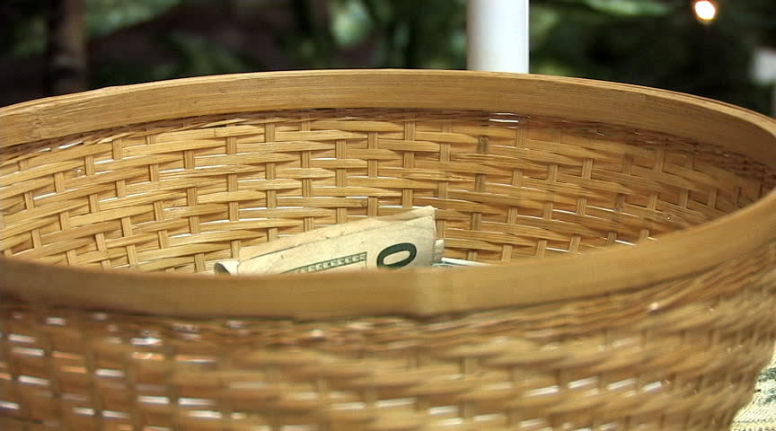 People place donations in the church tithing basket.