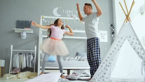 Joyful father and his little daughter dancing at home
