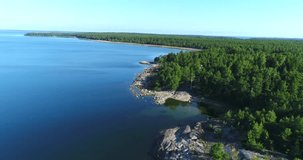 Rocky coast, Cinema 4k aerial view over cliffs and rocks on a shore and a beach, in finnish archipelago, on a sunny morning, in Padva, Uusimaa, Finland 