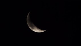 Clouds pass in front of the waning crescent moon as it moves slowly across the sky due the rotation of the earth. - Powered by Shutterstock - Get 15% off with code: PIKWIZARD15