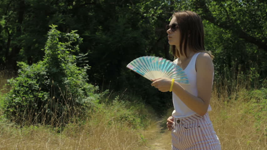 Young cute girl with fan, outdoor