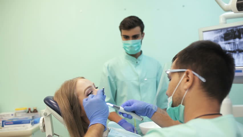 Dentist using dental curing UV lamp on teeth of patient | Shutterstock HD Video #29899126