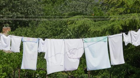 Fresh clean clothes are drying outside in the garden