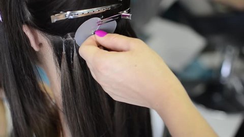 Hairdresser installs the upgrade of hair extension to the client in the salon, Hair extension with keratin concept and close up