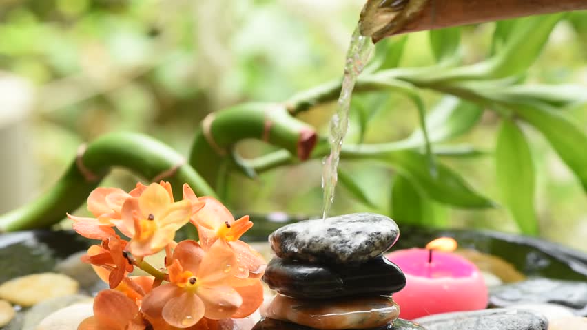 Spa background with waterfall from bamboo flowing on the rock.