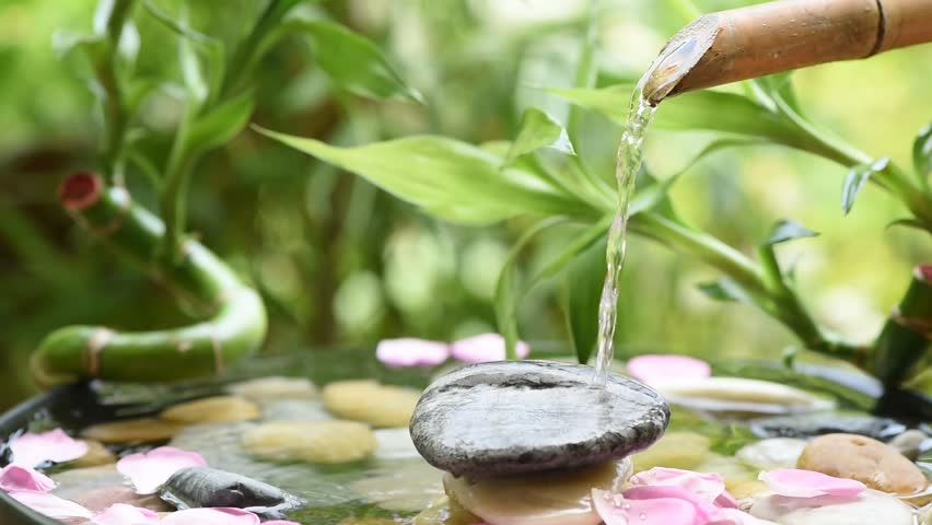 Spa background with waterfall from bamboo flowing on the rock.