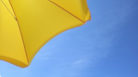 Yellow parasol against the blue summer sky
