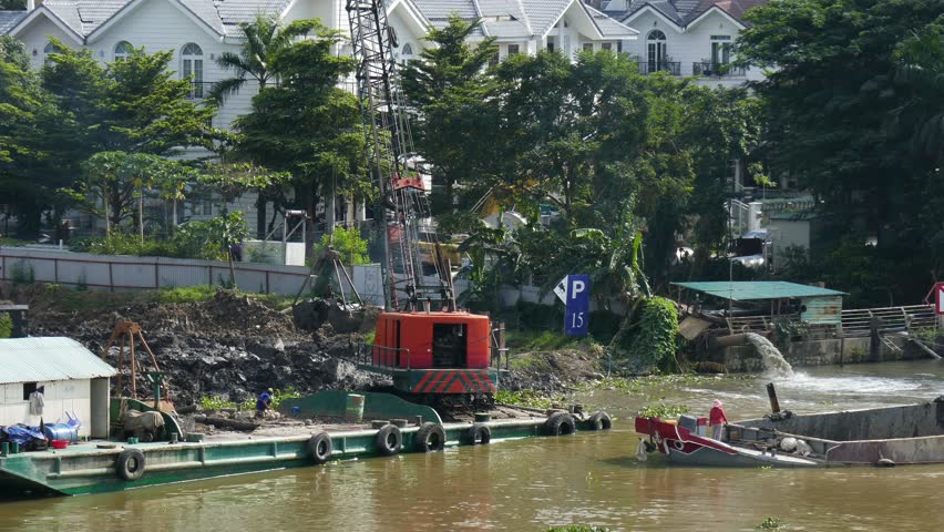 Ho Chi Minh city, Vietnam - August 12, 2017:  Crane transport mud from ship come off land