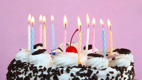 Happy birthday cake with candles on pink background
