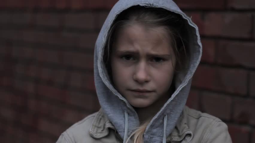 Refugee homeless child. Dark portrait of preteen girl standing in front of brick wall, she is looking unhappy and angry. | Shutterstock HD Video #29922190
