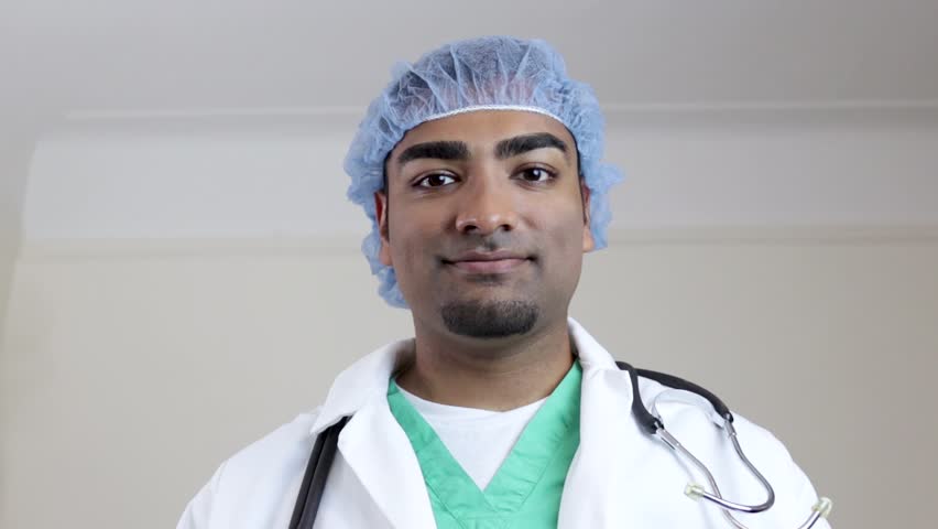 Surgeon looking forward placing mask on face 
