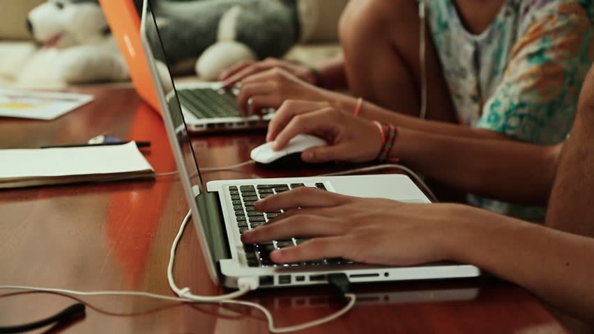 A guy and a girl are working on a design on a laptop.
