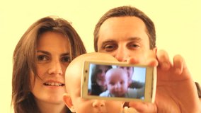 Happy young family, father, mother and child, shooting themselves with a mobile phone