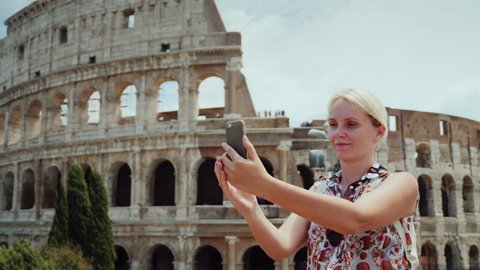 A woman is photographed against the background of the famous Colosseum in Rome
