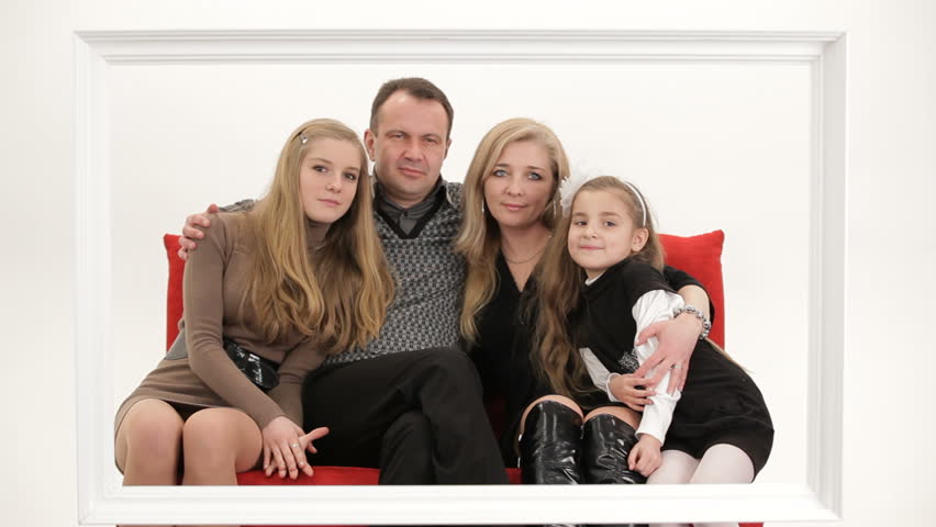 A family posing on a couch and then walking away in opposite directions.
A family picture.
