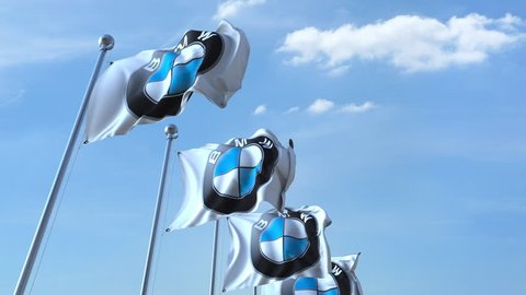 Waving flags with BMW logo against sky, seamless loop. 4K editorial animation