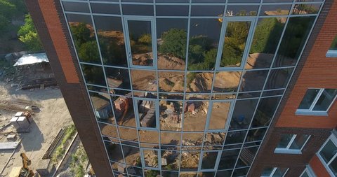 Aerial view a new building house with mirrored windows with reflection of morning landscape above river