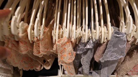 Shop of women's underwear. Women's panties on hangers in a sex store, 4k, slow motion