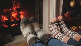 Slow motion video of family with child wearing woolen socks warming by the fireplace