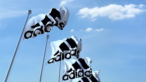 Waving flags with Adidas logo against sky, seamless loop. 4K editorial animation