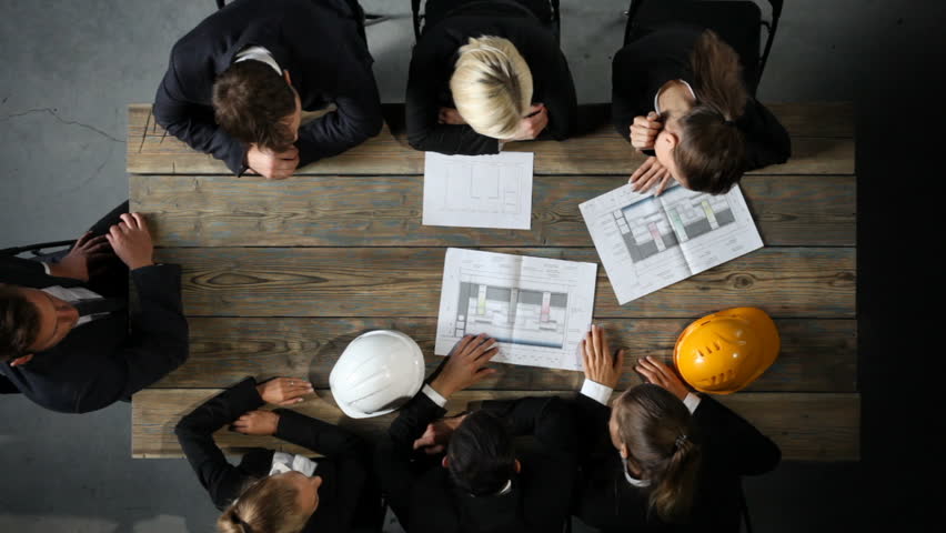 Business people discuss construction blueprint, hardhat on office table Royalty-Free Stock Footage #29955703