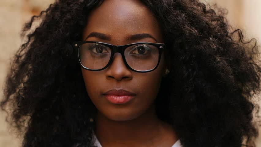 Close up portrait of beatiful curly hair african woman in the glasses smiling on the camera on the street background. Royalty-Free Stock Footage #29957095