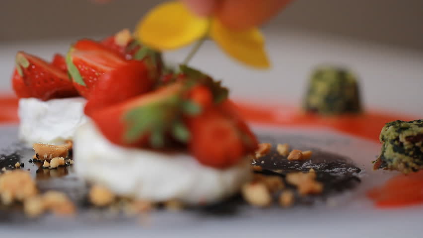 A delicious creative foodie gourmet Goat Cheese and Strawberries, granola, kale. Meal is being given the finishing touches by the chef cook presentation in a restaurant or hotel kitchen cuisine. Royalty-Free Stock Footage #29960200